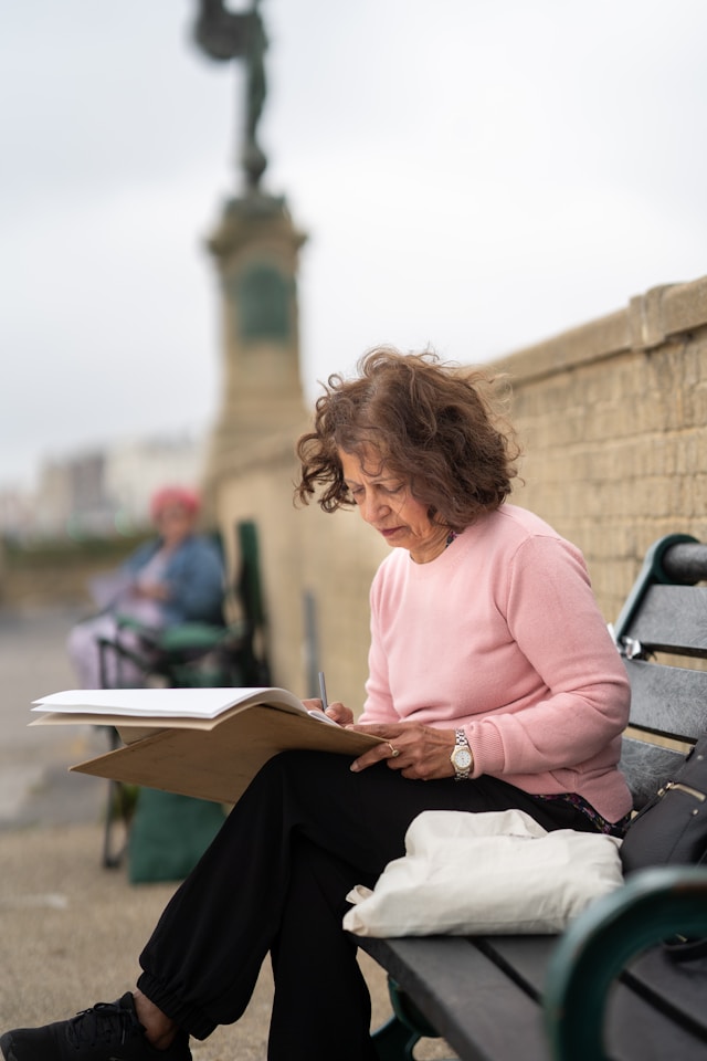 lady sketching outside on bench