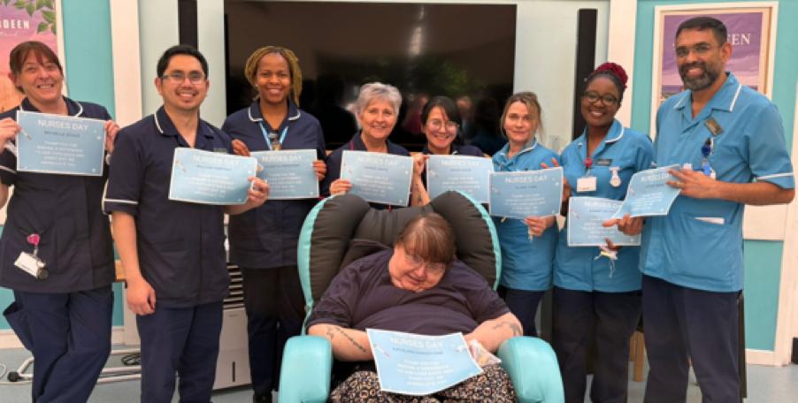 staff smiling and holding certificates with resident